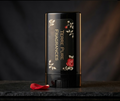Black perfume bottle with floral design on a dark background