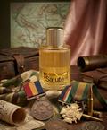 Perfume bottle labeled 'Salute' surrounded by military-themed items on a wooden surface.