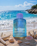 Blue bottle of Terre Pure Ventus East on a beach with ocean and rocks in the background