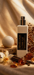 White Lava bath essentials bottle with vanilla beans and flowers on a textured background